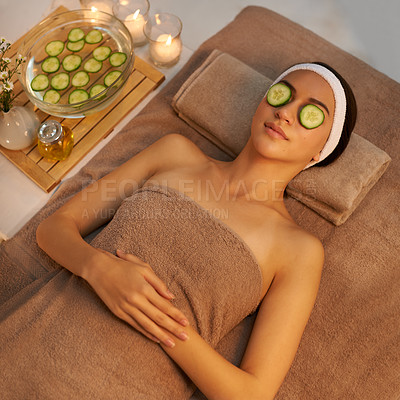Buy stock photo Top view, skincare and woman with cucumber on face at massage table in spa for peace, relax or wellness. Facial, above or person with vegetable on eyes for natural beauty or healthy organic treatment