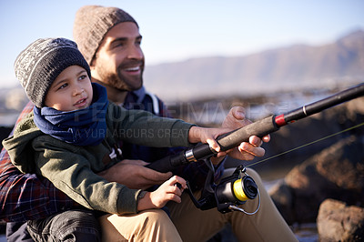 Buy stock photo Shot of a loving father and son fishing by the sea
