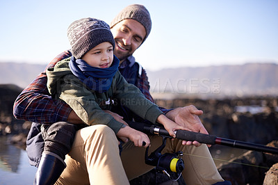 Buy stock photo Father, kid and fishing at sea in winter as hobby with bonding for child development, growth and life skills in Australia. Dad, boy and sit at rock in coast for family tradition, memory and care
