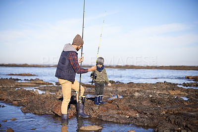 Buy stock photo Father, boy and fishing at sea in winter as hobby with bonding for child development, learning and growth in Australia. Dad, kid and stand in boulders at coast for family tradition, memory and care