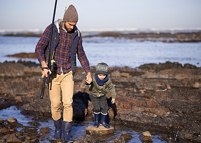 Buy stock photo Man, kid and fishing at sea in winter as hobby with bonding for child development, growth and life skills in Australia. Dad, boy and stand in boulders at coast for family tradition, memory and care