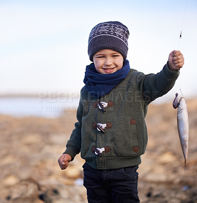 Buy stock photo Portrait, boy and smile with nature, fish and happiness for achievement on break. Child, water and ocean with rocks, adventure and vacation on fishing trip with childhood memories and fun success