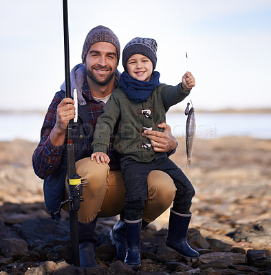 Buy stock photo Portrait of a cute little boy holding the fish he caught with his dad