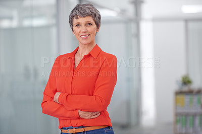 Buy stock photo Portrait of a mature businesswoman standing with her arms crossed in an office setting
