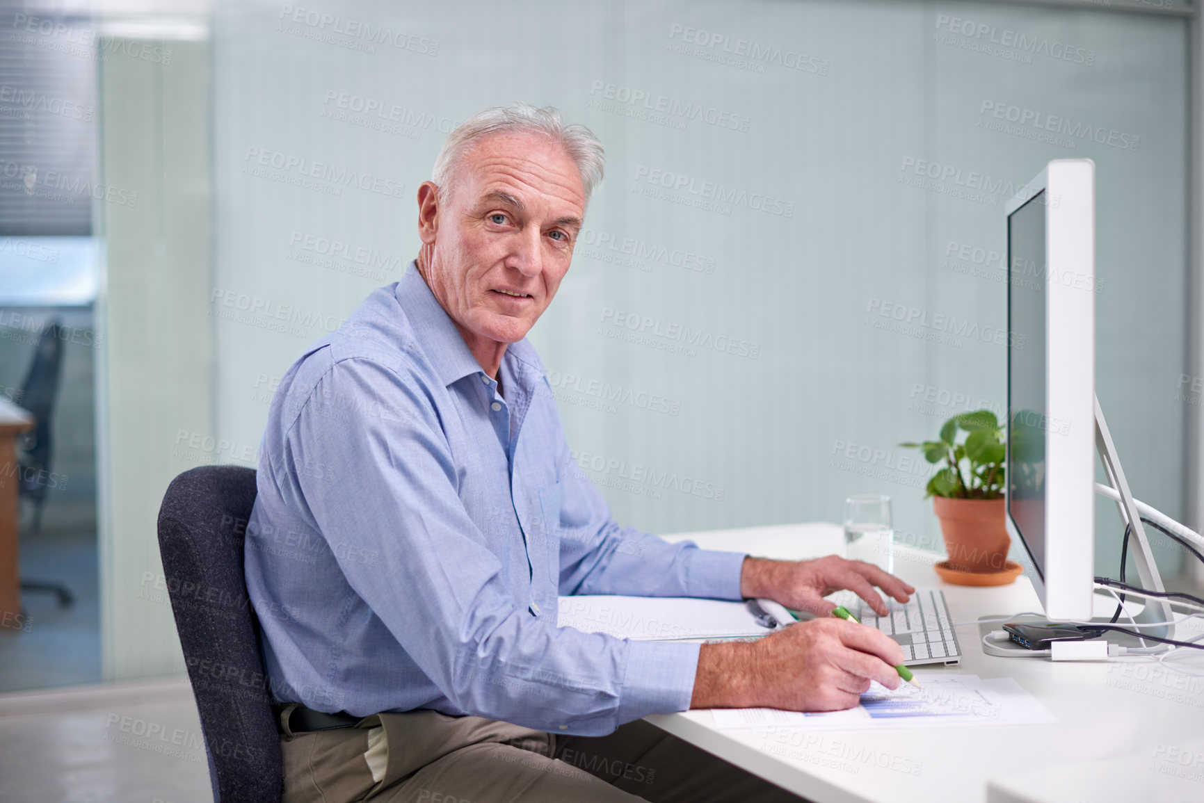 Buy stock photo Portrait of a mature businessman working at his office desk