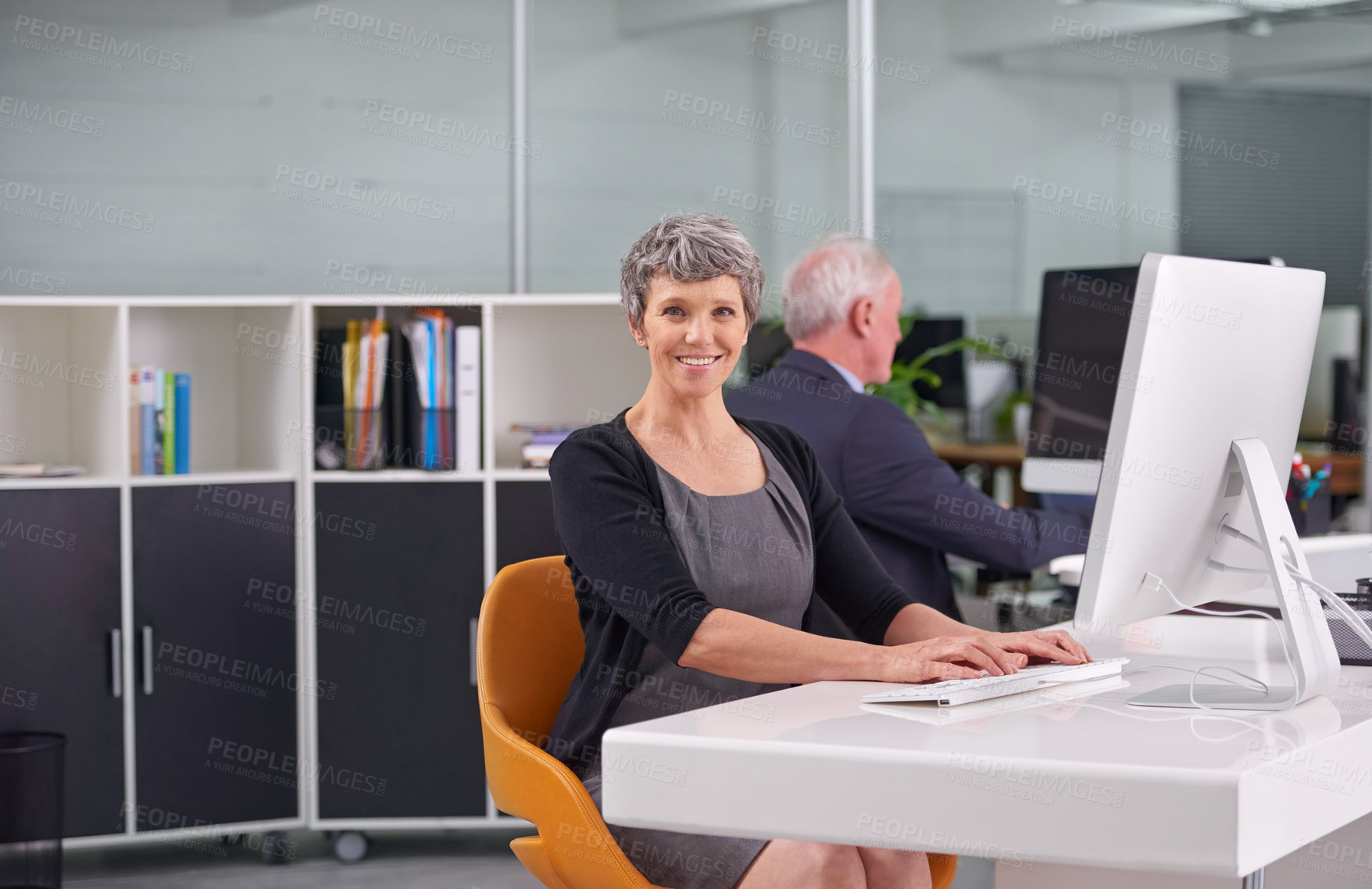 Buy stock photo Business, mature and portrait of woman typing on pc in office with male colleague, senior management or supervisor for corporate company. Person, technology and online for performance monitoring