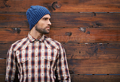 Buy stock photo Shot of a handsome young man in trendy winter attire against a wooden background