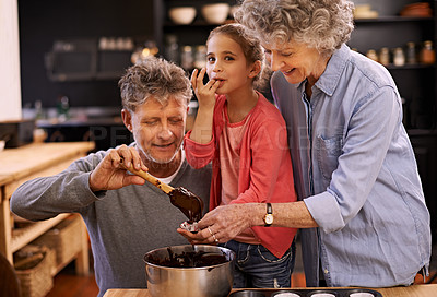 Buy stock photo Portrait of a little girl and her grandparents making cupcakes in the kitchen
