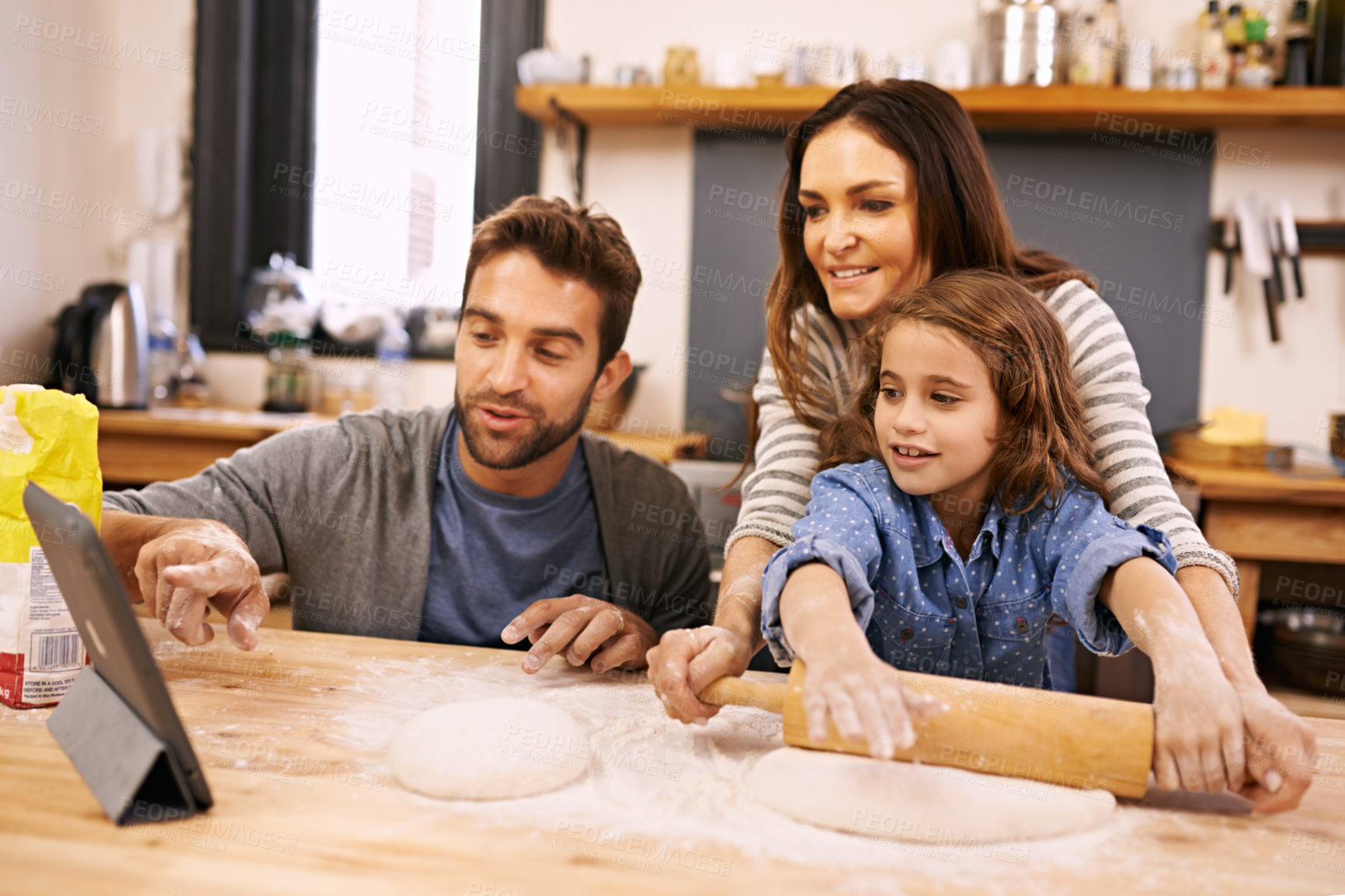 Buy stock photo Family, cooking and learning in kitchen with tablet for recipe, guide and parents with child in home. Baking, mom and dad helping girl with rolling pin and reading about pizza, dinner or meal prep