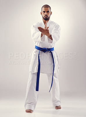 Buy stock photo Studio, karate and black man training for power for physical health with fitness and effective technique. White background, male person and adult with disciple of martial arts, sport and blue belt