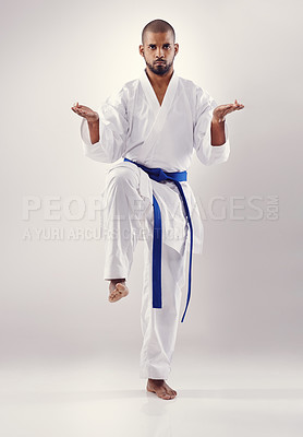 Buy stock photo Studio, karate and African man training to improve physical health with fast and effective technique. White background, male person and adult with disciple of martial arts, sport and blue belt