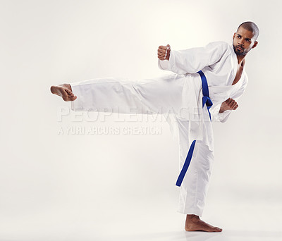 Buy stock photo Man, kick and karate fighter in studio, fitness and martial arts on white background. Black male person, athlete and blue belt for taekwondo, discipline and warrior ready for self defense or battle