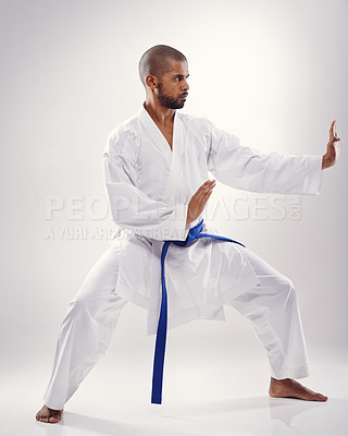 Buy stock photo Studio, karate and black man with martial arts, training and blue belt for instructor in white background. Discipline, male person and adult with technique for health, goju ryu and movement for power