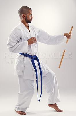 Buy stock photo Nunchaku, karate and man in martial arts fight with weapon in training for defence in white background of studio. Nunchucks, exercise and fighting with equipment in sport with skill and power in gym