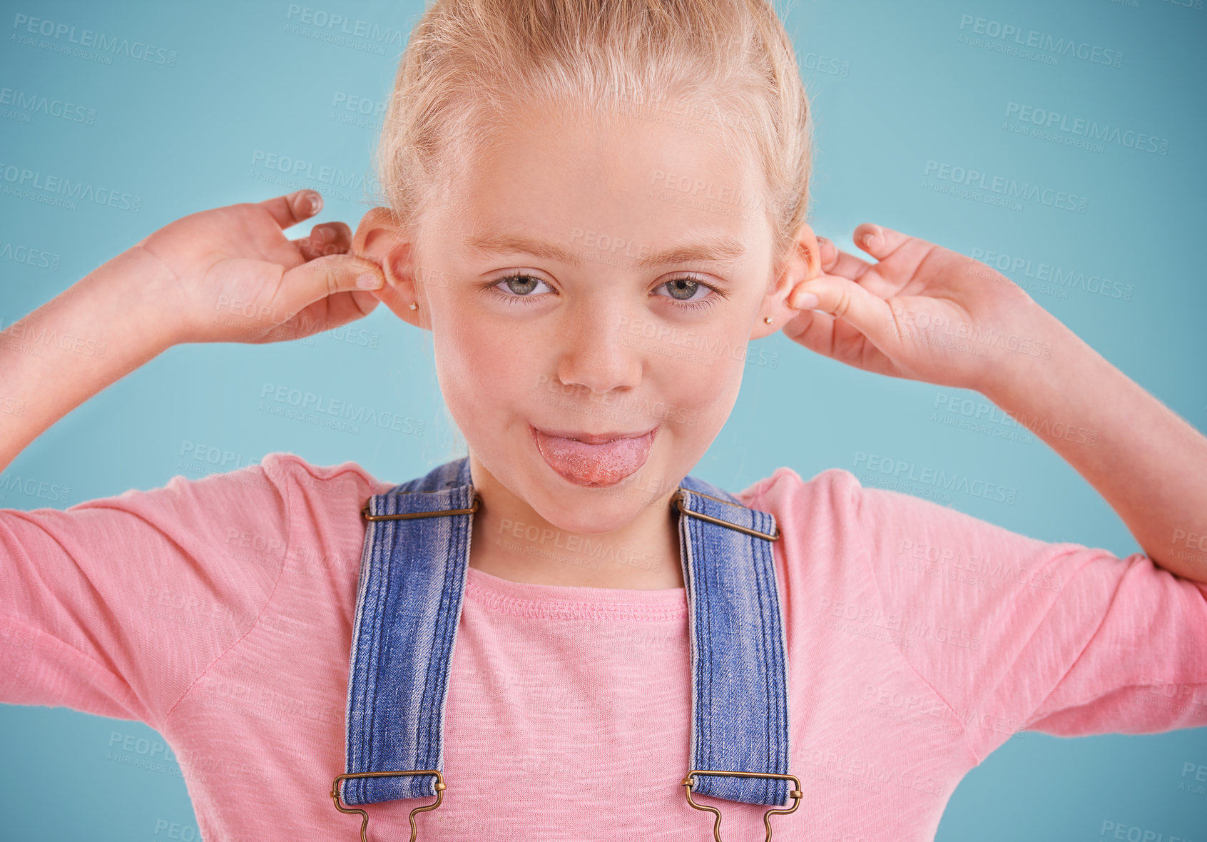 Buy stock photo Child, portrait and tongue out in studio for goofy, silly and playful facial expression with blue background. Happy, crazy and funny face of young girl for comic, humor and joking for comedy