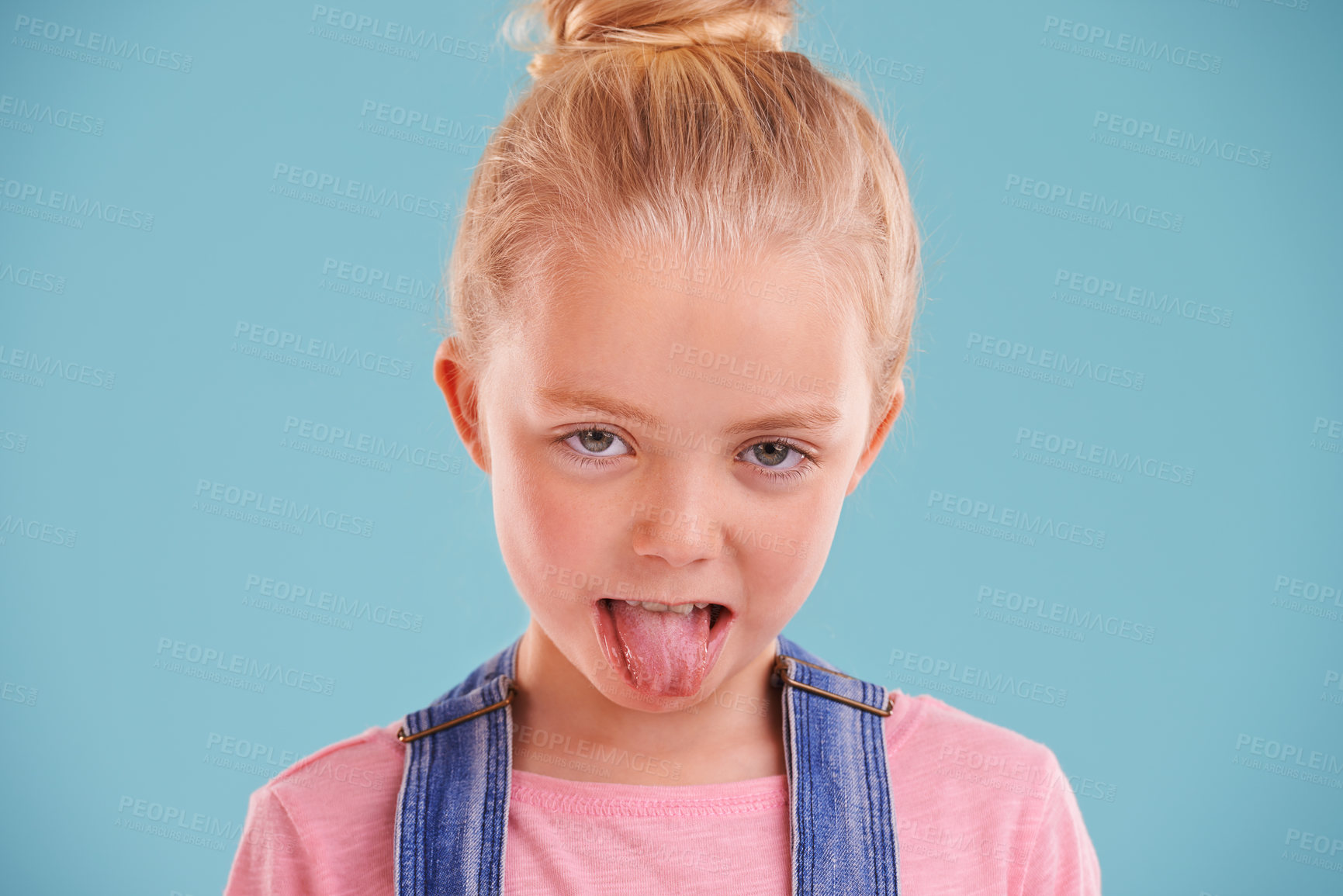 Buy stock photo Kid, portrait and tongue out in studio for silly, goofy and playful facial expression with blue background. Child, crazy and funny face of young girl for comic gesture, humor and joking for comedy