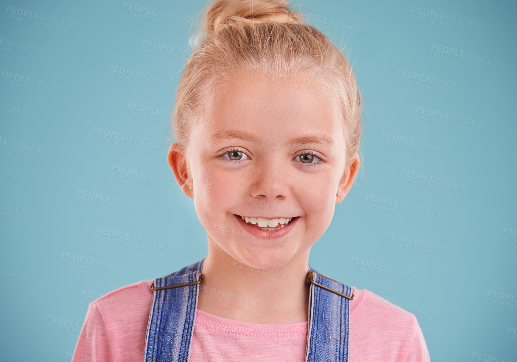 Buy stock photo Portrait, girl and kid with smile, happiness and cheerful child on a blue studio background. Face, mockup space or model with expression or excited with emotion or joyful with fun or funny with peace