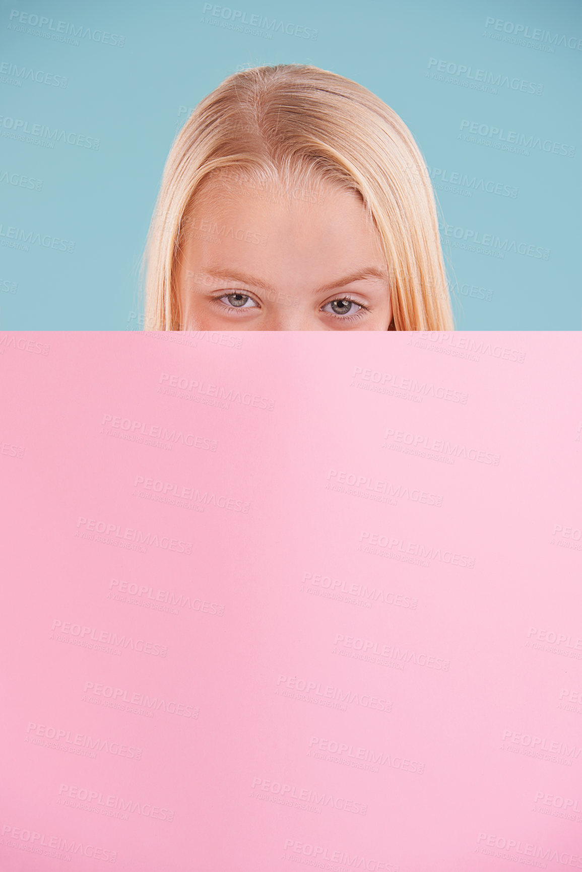 Buy stock photo Child, portrait and poster mockup in studio for information opinion with announcement, presentation or blue background. Female person, face and billboard placard with space, banner or development