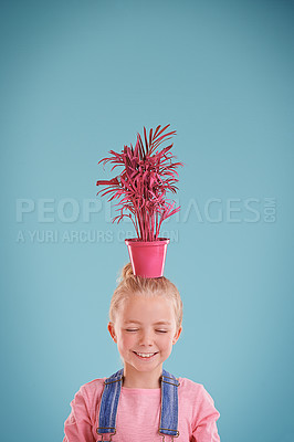 Buy stock photo Smile, pot and child with plant in studio with positive, good and confident attitude for decoration. Funky, mockup and young girl kid with eco friendly pink flower on head isolated by blue background