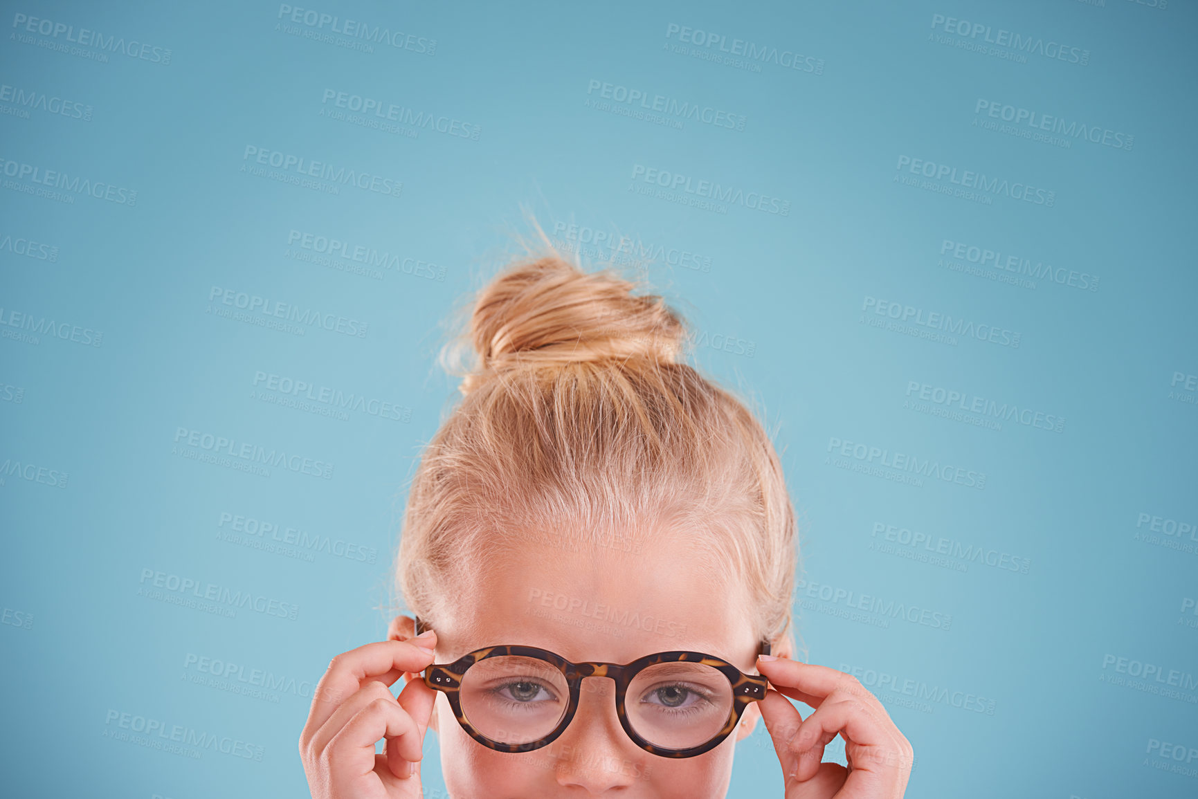 Buy stock photo Child, portrait and glasses in studio for vision optometry on blue background for frames, wellness or mockup space. Girl, kid and face with eyewear healthcare for sight spectacles, lens or optical