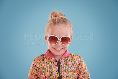 Buy stock photo Child, portrait and fashion with sunglasses in studio for trendy, cool and funky style with confidence. Cute girl, smile and happy in blue background, young kid and retro clothes with glasses