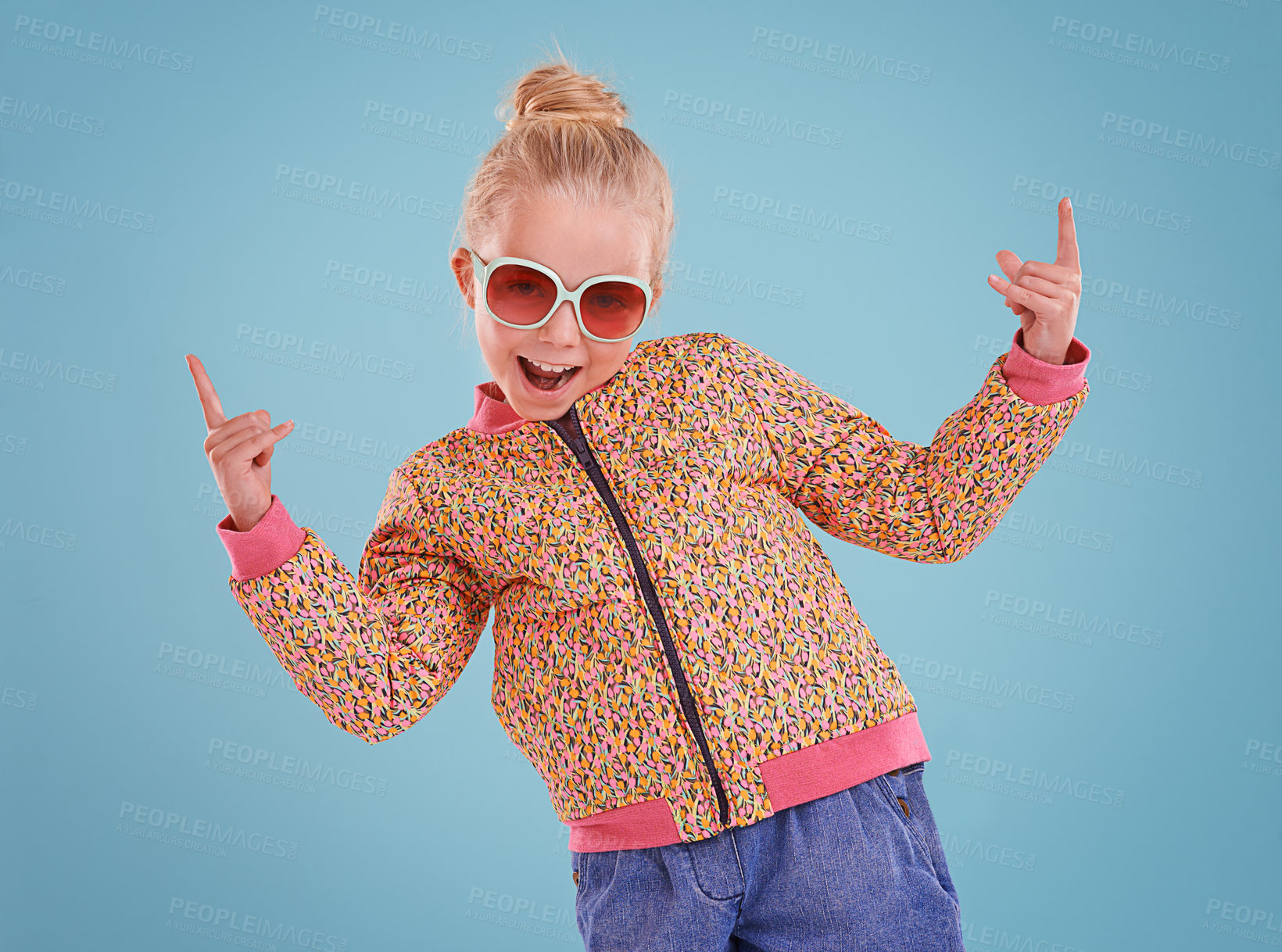 Buy stock photo Happy, sunglasses and portrait of child in studio with funky, trendy and stylish jacket for outfit. Excited, pointing and face of girl kid model with cool fashion and accessory by blue background.