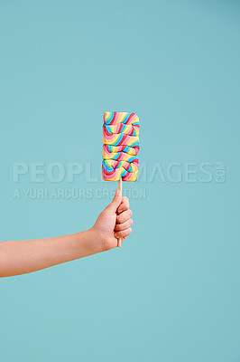 Buy stock photo A little girl's hand holding a hard candy lollipop