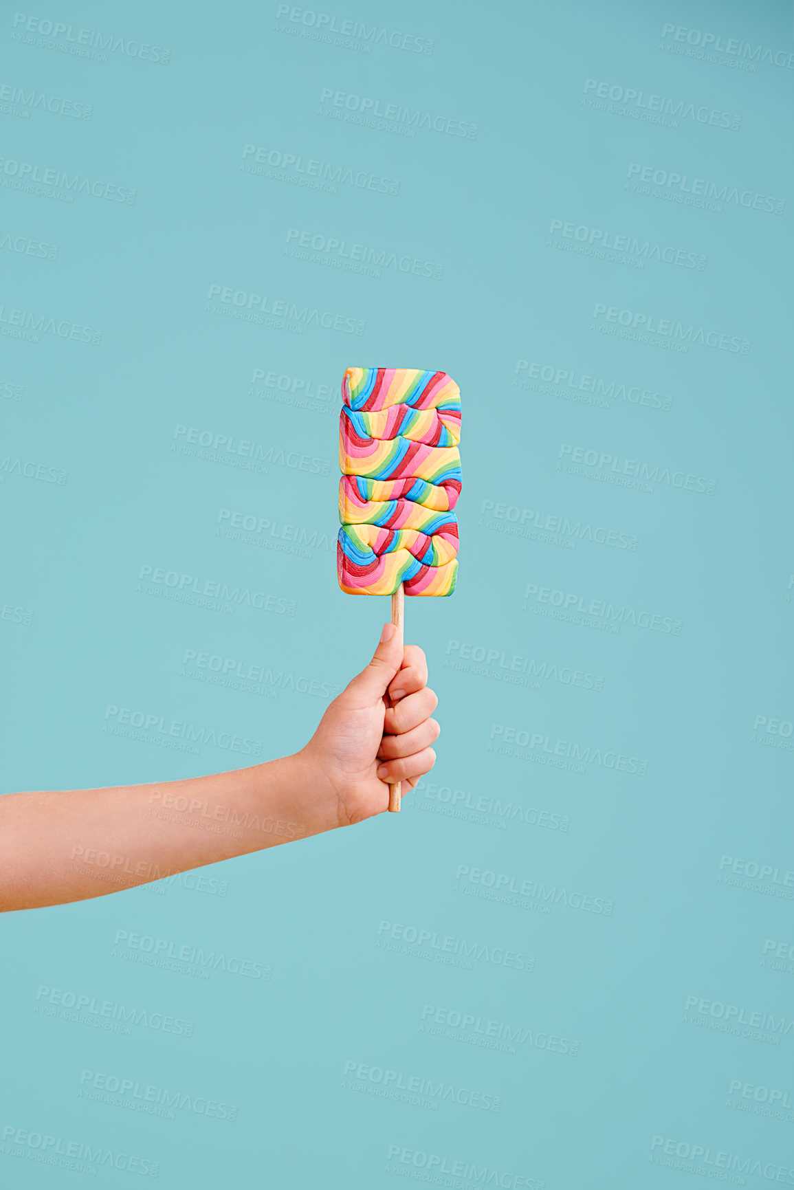 Buy stock photo A little girl's hand holding a hard candy lollipop