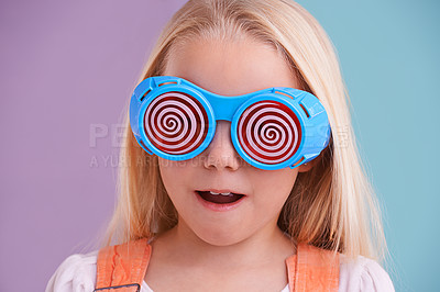 Buy stock photo A cute little girl wearing funny sunglasses against a colorful background