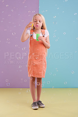 Buy stock photo Fun, playing and kid blowing bubbles in studio with activity for child development and hobby. Youth, toy and young girl model with casual, cool and trendy style isolated by color block background.