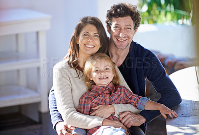 Buy stock photo Family in portrait, mother and father with child in backyard, relax together with love and care outdoor. Happy faces of people outside home, hugging with smile and woman, man with girl in a garden