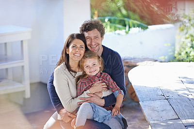 Buy stock photo Happy family, portrait and relax in garden of home with embrace, happiness and weekend break in summer. Parents, girl child and face with smile in backyard of house with healthy relationship and hug
