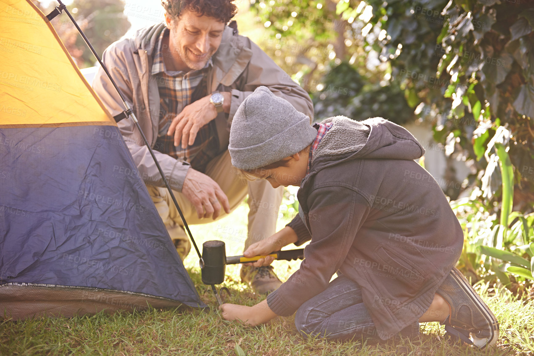 Buy stock photo Father, child and hammer tent for camping outdoor in nature on vacation, bonding together and summer break. Happy dad, boy and preparing camp, learning and helping in forest for travel and education.
