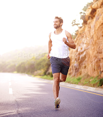 Buy stock photo Full length shot of a handsome young man running on a road