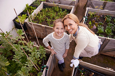 Buy stock photo High angle portrait of a mother and daughter gardening together in their backyard