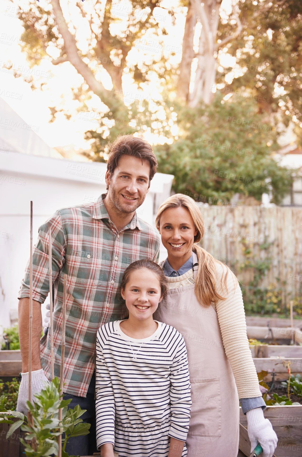 Buy stock photo Portrait of a happy family gardening together in their backyard