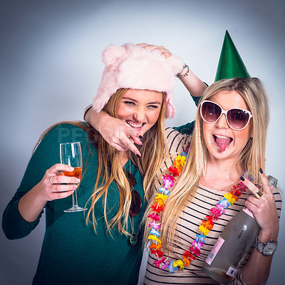 Buy stock photo Friends party, alcohol and drinking by studio background for celebration, new year and happiness. Happy drinks, women and funny hat with glass, bottle and hug for festive cheers, smile and celebrate