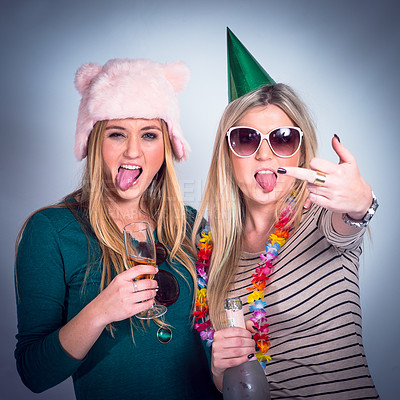 Buy stock photo Party, drunk friends and drinking alcohol for celebration while crazy, rude and happy on studio background. Women with wine glass and bottle showing middle finger to celebrate birthday drink together