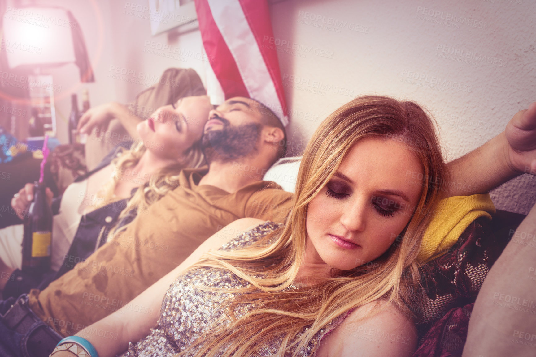 Buy stock photo Drunk, sleeping and real people at a party on a sofa with a hangover from a celebration at a house. Tired, alcoholic and young man taking a nap with women on a couch at a home event in America.