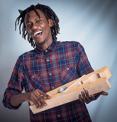 Buy stock photo Portrait, prop and happy man holding giant peg looking cheerful on a grey studio background. Face, front and laughing, joyful african american male holding a clothes peg on a studio backdrop