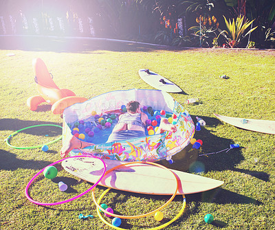 Buy stock photo Man, backyard and passed out on grass, drinking and party in summer at with butt open in kids pool. Drunk person, sleeping and lawn with toys, sunshine or hangover on vacation, holiday or celebration