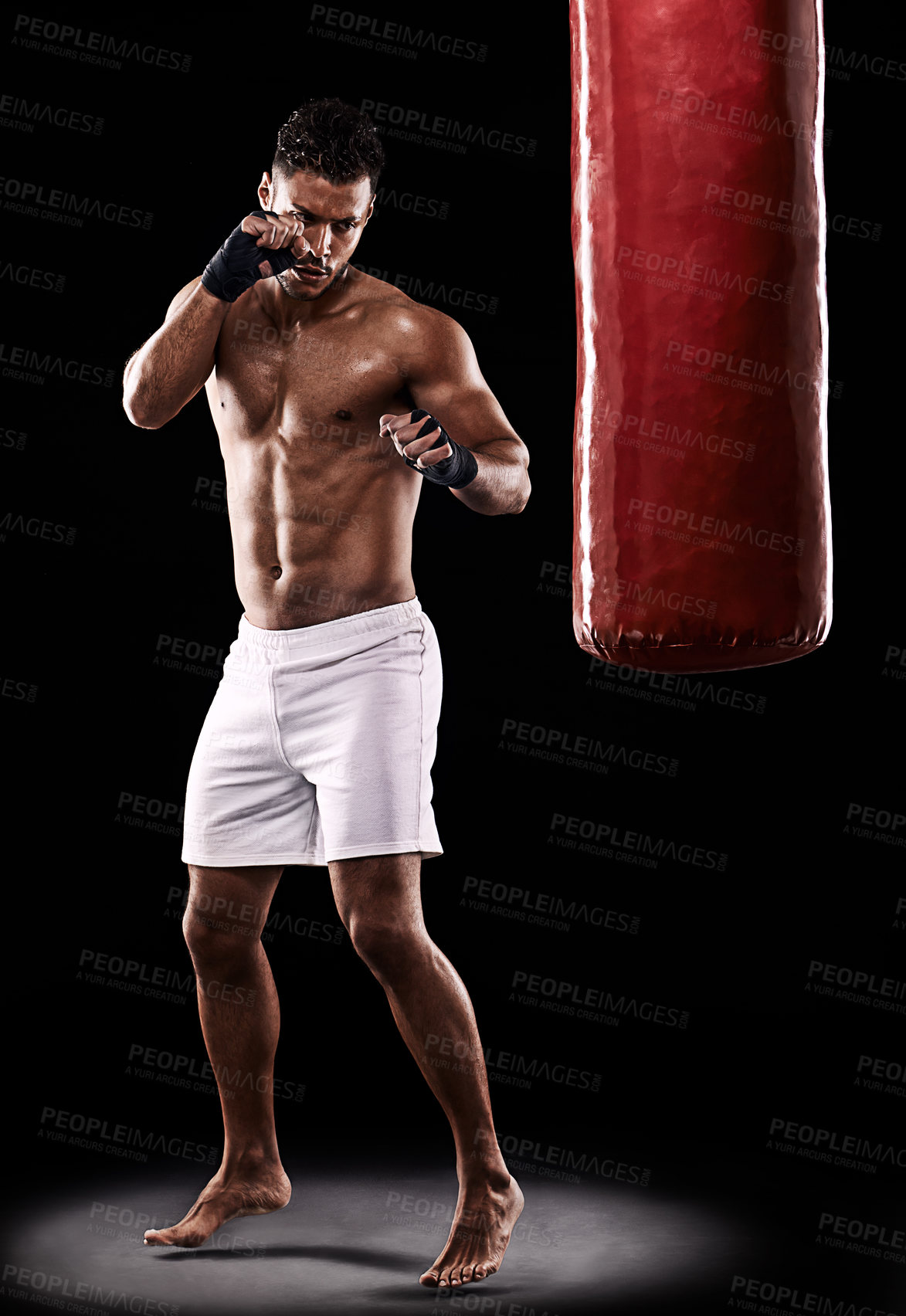 Buy stock photo Fitness, punching bag and man boxer in studio for body, training or performance on black background. Fighter, impact and topless male athlete with martial arts, mama or kickboxing match practice