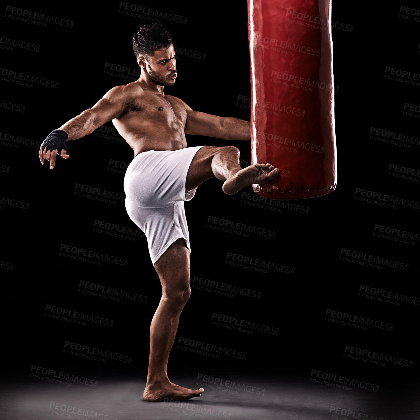 Buy stock photo Kickboxing, man and training in studio with punching bag for workout, exercise or competition fight with fitness. Athlete, boxer and strong for martial arts with power and topless on black background