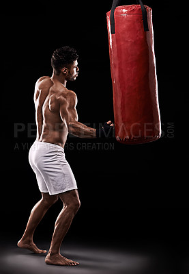 Buy stock photo Practice, boxer and man with punching bag in studio with gloves for training with strength and muscle. Adult, athlete and male person in dark background, healthy and power with body, job and sport