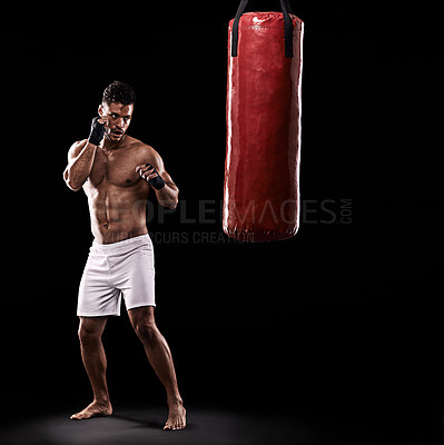 Buy stock photo Ready, boxer and man with punching bag in studio with gloves for training with strength and muscle. Adult, athlete and male person in dark background, healthy and power with body, serious and sport