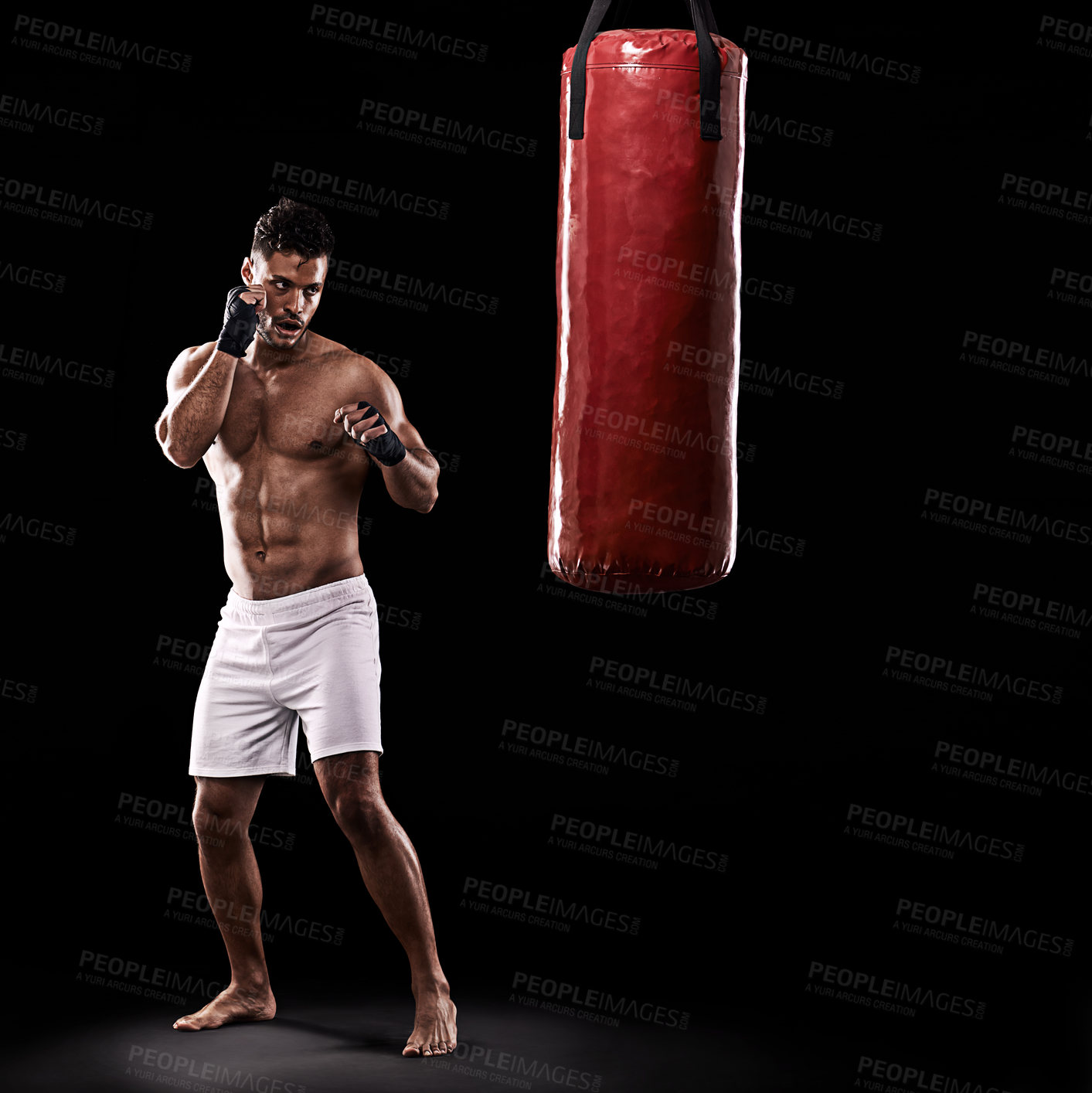 Buy stock photo Ready, boxer and man with punching bag in studio with gloves for training with strength and muscle. Adult, athlete and male person in dark background, healthy and power with body, serious and sport