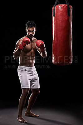 Buy stock photo Portrait, boxing bag and gloves for male boxer, studio and  athlete on black background. Dark, training and combat sports or MMA for man model, workout, muscle and impact activity for martial arts
