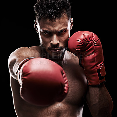 Buy stock photo Portrait of a young man wearing boxing gloves against a black background