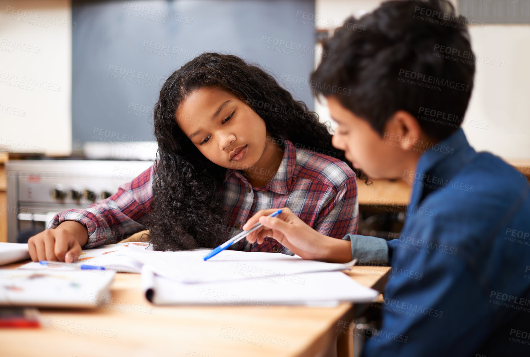 Buy stock photo Shot of two young students studying together in a classroom