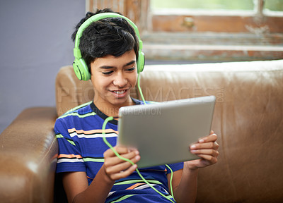 Buy stock photo Cropped shot of a little boy watching a video on his tablet